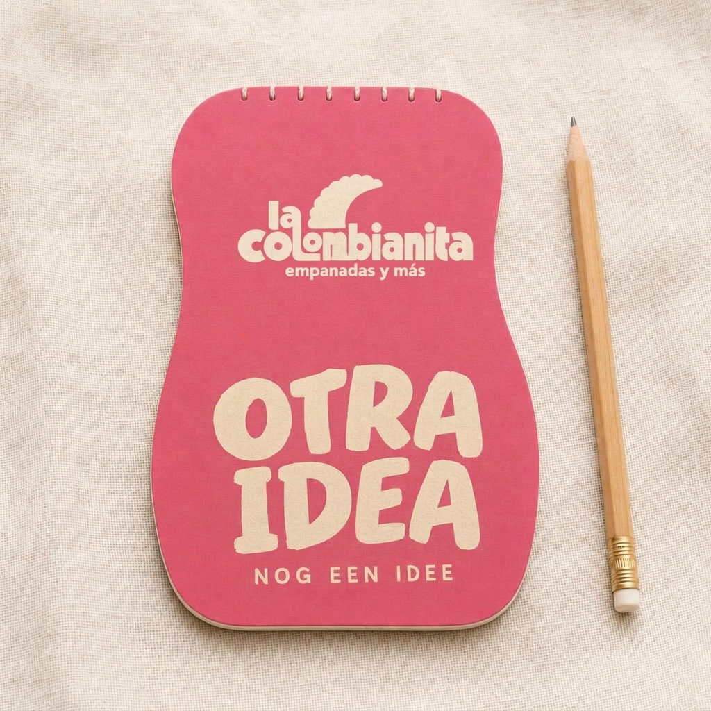 Roze kladblokje met het logo van La Colombianita en de tekst OTRA IDEA naast een potlood