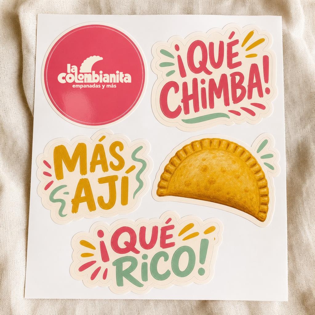 Stickervel van La Colombianita met logo, empanada en de kreten ¡QUÉ CHIMBA!, MÁS AJÍ en ¡QUÉ RICO!